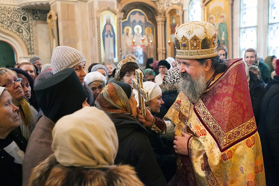 батюшка благословляет людей 